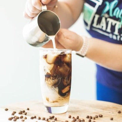 Pouring cream into iced coffee